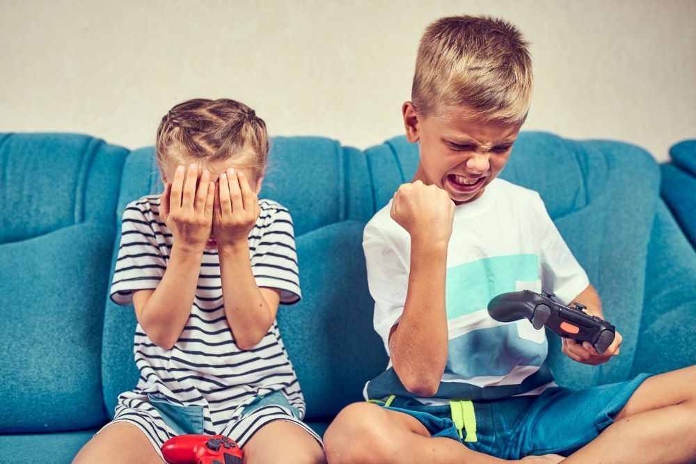Хлопчик і дівчинка емоційно реагують на невдачу та перемогу у відеогрі 