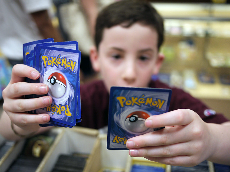 Хлопчик уважно роздивляється картки з покемонами